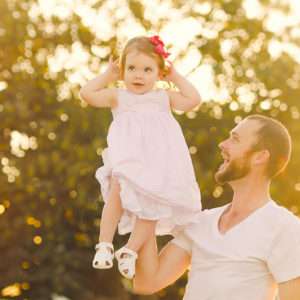 Dad laughing as he lifts his laughing toddler in golden hour light, family photography session by Twin Lotus Production, Brisbane family photographer