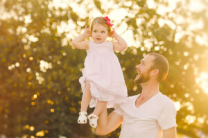 Dad laughing as he lifts his laughing toddler in golden hour light, family photography session by Twin Lotus Production, Brisbane family photographer